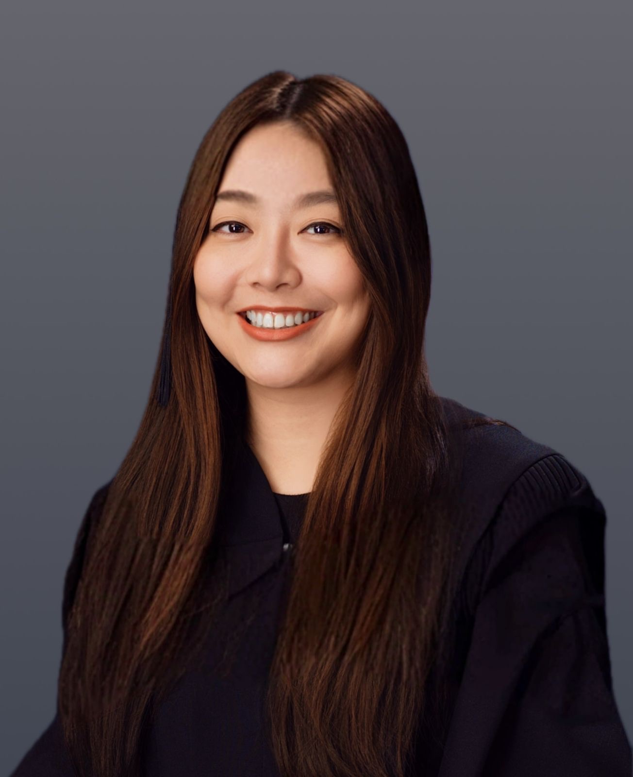 Supplied portrait of Melinda smiling against a grey background.